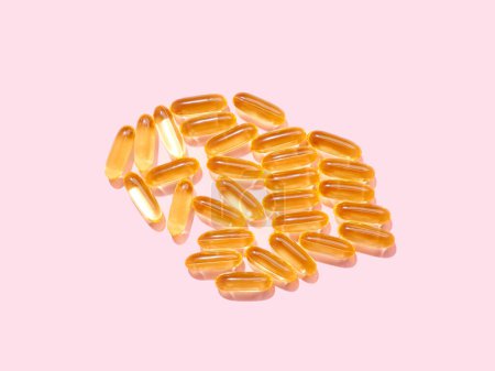 Foto de Omega 3 píldoras translúcidas doradas sobre fondo rosa plano - Imagen libre de derechos