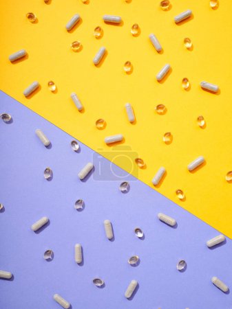 Foto de Varias píldoras de suplementos alimenticios en fondo colorido - Imagen libre de derechos