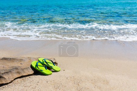 Foto de Chanclas de colores junto a la orilla en una playa vacía - Imagen libre de derechos