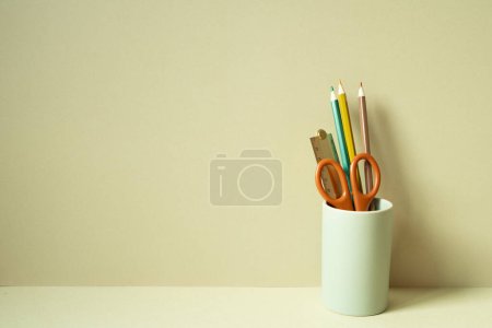 Foto de Escribir suministros portalápices en el escritorio. fondo beige caqui - Imagen libre de derechos