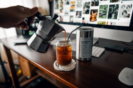 Kaffee aus einer Mokka-Kanne in ein Glas gießen