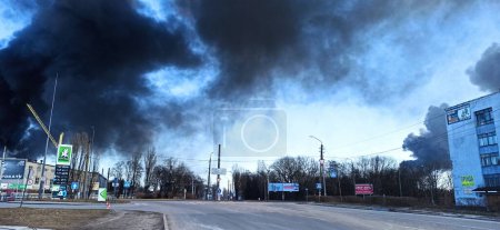 Téléchargez les photos : Smoke from fire on outskirts of the city after an air strike by Russian aircraft on the city of Chernihiv. Horrors of war in Ukraine. Chernihiv is hero city. Fire during the war - en image libre de droit