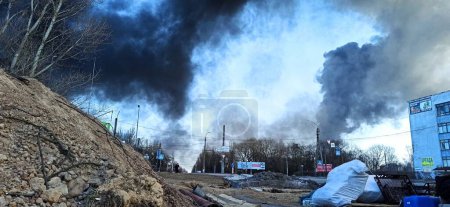 Téléchargez les photos : Fumée de feu dans la ville de Tchernihiv après une frappe aérienne par des avions russes. guerre en Ukraine. Horreurs de la guerre en Ukraine. Fumée noire contre le ciel - en image libre de droit