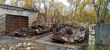 Photo for Burnt cars in destroyed garages during war in Ukraine. Destroyed cars. Burnt transport after shelling of Russian army of city in Ukraine. Russian-Ukrainian War. Destroyed buildings and cars during war - Royalty Free Image