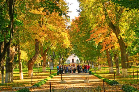 Photo for Ckachanivka village - Chernihiv region- Ukraine. 01 October 2017: Crowd of tourists listening to guide during excursion around old park in autumn. People walk on autumnal city park. People take a tour in old autumn park - Royalty Free Image