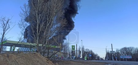 Téléchargez les photos : Smoke from fire on outskirts of the city after an air strike by Russian aircraft on the city. Horrors of war in Ukraine. Black smoke against sky. Fire during the war. Disaster - en image libre de droit