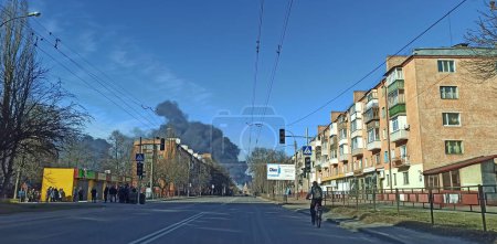 Téléchargez les photos : Tchernihiv - Ukraine. 25 mars 2022 : Fumée d'incendie dans la ville de Tchernihiv après une frappe aérienne par des avions russes sur la ville. Horreurs de la guerre en Ukraine. Fumée noire contre le ciel. Feu pendant la guerre. Hénocide - en image libre de droit