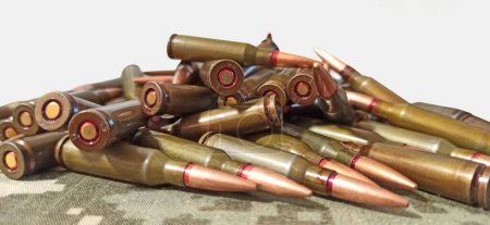 Cartridges for Kalashnikov assault rifle. War concept. Pile of cartridges with bullets. Heap of bullets against white background. Military concept. War for freedom and independence. Heap of billets