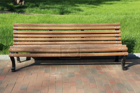 Photo for Wooden bench in the park. beautiful bench in city park. Empty bench in beautiful park with green grass. Summer park with place for rest - Royalty Free Image