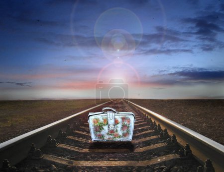Photo for Old suitcase standing on rails. Farewell to old life. Travel symbol. Railway rails with suitcase. Travel bag on road with sunset. Sunny rays of raising sun. Hope for future. Sunny rays of decline - Royalty Free Image
