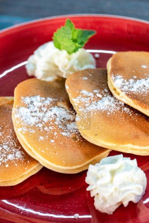 Photo for A image of freshly made American style pancakes severed with fresh fruit and cream - Royalty Free Image