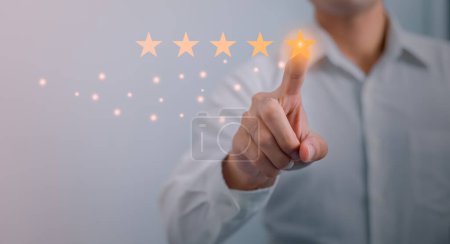 Customer service and Satisfaction concept ,Business people are touching the virtual screen on the happy Smiley face icon to give satisfaction in service. rating very impressed.