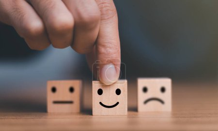 Photo for Close up customer hand choose smile face and blurred sad face icon on wood cube, Service rating, Customer service evaluation and satisfaction survey concepts. - Royalty Free Image