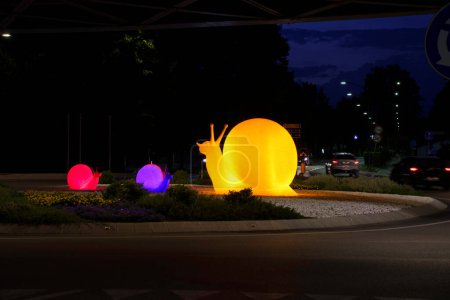 Téléchargez les photos : Statues d'escargots dans un rond-point à Mestre, Venise, Italie, de nuit - en image libre de droit