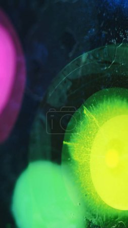 Ink splash water. Paint blob. Blur vibrant yellow green pink blue color oil fluid bubbles sphere explosion abstract art background.