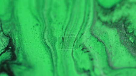 Glitter ink liquid. Oil fluid flow. Defocused neon green black color drip paint emulsion gloss particles wave motion abstract art background.