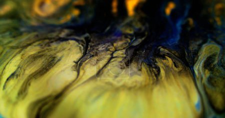 Derrame de tinta. Textura líquida brillo. Desenfocado negro azul amarillo color metálico brillante polvo dorado partículas pintura goteo emulsión fuga abstracto arte fondo.