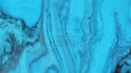 Tintentropfen fließen. Glitzernde Acryltextur. Verwischen hell blau schwarz Farbe Welle nass schimmern Serum funkelnde Ölfarbe mischen abstrakte Kunst Hintergrund.