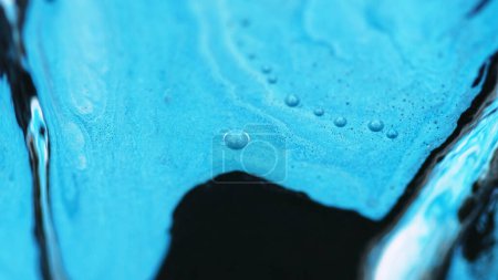 Tuscheemulsion. Flow Mix schimmern. Defokussiert blau schwarz Farbe Tropf Ölfarbe nass glänzend glitter flüssige Mischung Welle Bewegung abstrakte Kunst Hintergrund.