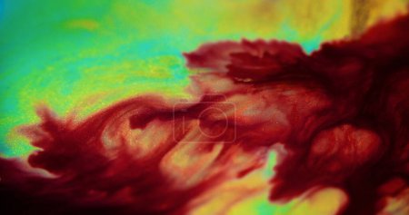 Ink spill. Shiny fluid texture. Blur red green cyan yellow color sparkling glitter particles water paint splash emulsion liquid blend abstract art background.
