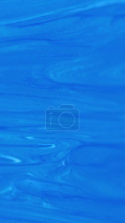 Ölfarbe schimmern lassen. Farbstoffaustritt. Defokussierte blaue Farbe Farbe Emulsion Glanz Flüssigkeit Gel Textur Glitzerpartikel abstrakte Kunst Hintergrund.