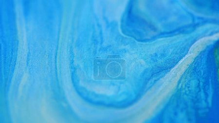 Glitter fluid. Flow texture art. Defocused blue silver color drip gel wave liquid paint wet gloss ink mix serum motion abstract background.