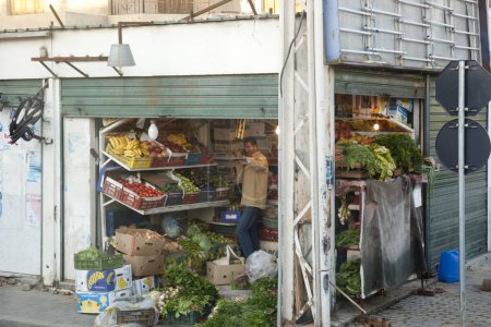 Téléchargez les photos : Tripoli, Libye, 4 novembre 2009. Un vendeur de fruits avec de délicieux fruits et légumes frais dans un magasin d'angle. La Libye cultive sa propre production entièrement sous irrigation. - en image libre de droit