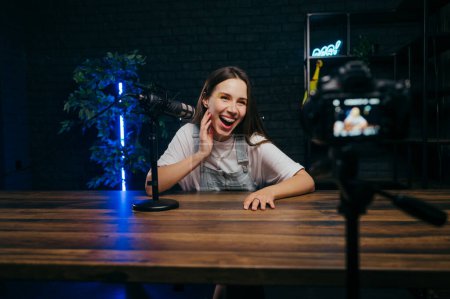 Photo for Backstage photo of a professional blogger at work creating videos, talking into a microphone and looking at the camera with a smile on his face. - Royalty Free Image