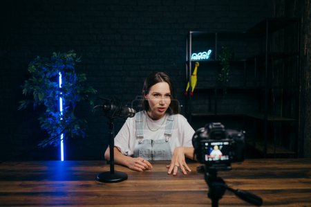 Photo for Process of creating videos in the studio. Female professional blogger records video on camera at home on location with light and equipment - Royalty Free Image