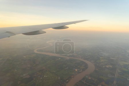 Photo for Wing of an airplane jet flying above clouds with blue sky from the window in traveling and transportation concept. Nature landscape background. - Royalty Free Image