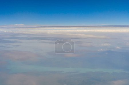 Photo for Airplane jet flying above clouds view with blue sky from the window in traveling and transportation concept. Nature landscape background. - Royalty Free Image