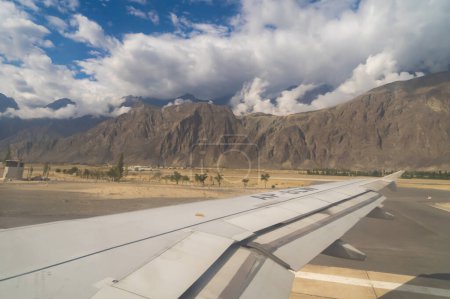 Photo for A wing of an airplane jet. The mountain hills view in Pakistan from the window in traveling and transportation concept. Nature landscape background. - Royalty Free Image