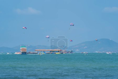 Photo for People flying in a colorful parachute or parasail together with blue sky and clouds in freedom and travel concept. - Royalty Free Image