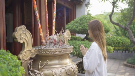 Foto de Retrato de una mujer vietnamita asiática rezando con incienso en un templo. - Imagen libre de derechos