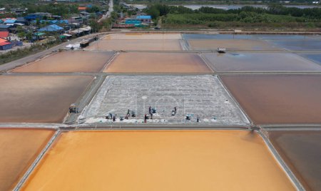 Téléchargez les photos : Vue aérienne du dessus des agriculteurs qui fabriquent des tas de sel marin brut avec la mer. Ferme en plein air. Matériel naturel dans l'industrie traditionnelle du sel en Thaïlande. La culture asiatique. Agriculture mode de vie - en image libre de droit