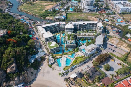 Téléchargez les photos : Aerial view of swimming pool on rooftop of hotel resort, apartment building with forest trees, urban city town. Relaxing in summer season in travel holiday vacation concept. Recreation lifestyle. - en image libre de droit