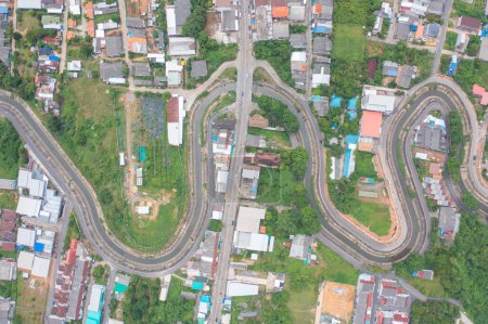 Téléchargez les photos : Vue aérienne de voitures conduisant sur une route courbe en zigzag ou une rue sur une colline de montagne avec des arbres forestiers naturels verts dans la ville rurale de Songkhla, Thaïlande. Transports. - en image libre de droit
