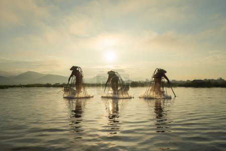 Foto de Pescador birmano lanzando o lanzando una red para la captura de peces de agua dulce en el lago Unle, río natural en Asia en Myanmar. Estilo de vida. - Imagen libre de derechos