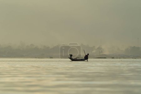 Photo for Burmese fisherman casting or throwing a net for catching freshwater fish in Unle lake, natural river in Asia in Myanmar. People lifestyle. - Royalty Free Image