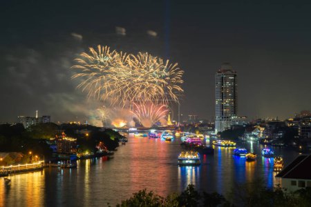 Fireworks at Memorial Bridge, and Phra Pok Klao Bridge with buildings and Chao Phraya River at night. Urban city, Downtown Bangkok, Thailand.
