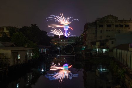 Foto de Celebración de fuegos artificiales en la Torre de Observación Samut Prakan con el reflejo del río en la ciudad urbana de Tailandia. - Imagen libre de derechos