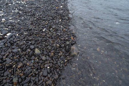 Foto de Granite gravel stone rocks flooring pattern surface texture on sea lake. Close-up of exterior material for design decoration background. Rubble - Imagen libre de derechos