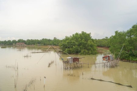 Foto de Red trampa de pesca en el canal con los pescadores de la ciudad urbana casas de pueblo, lago o río. Naturaleza paisaje pesca y herramientas de pesca en Pak Pha, Songkhla, Tailandia. Acuicultura - Imagen libre de derechos