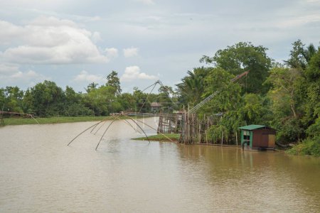 Fischfangfangnetz im Kanal mit Fischern städtischen Dorfhäusern, See oder Fluss. Naturlandschaftsfischerei und Angelwerkzeuge in Pak Pha, Songkhla, Thailand. Aquakultur