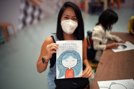 Photo for Asian women with mask showing her coloring in an art class - Royalty Free Image