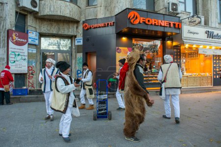Foto de 14 de diciembre de 2022- Bucarest, Rumania - personas bailando con trajes tradicionales y disfraz de oso a medida que se acerca la Navidad y el Año Nuevo - Imagen libre de derechos