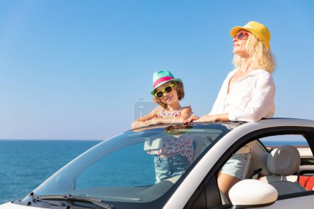 Téléchargez les photos : Bonne famille voyage en voiture à la mer. Mère et enfant s'amusent dans le cabriolet bleu. Concept vacances d'été - en image libre de droit