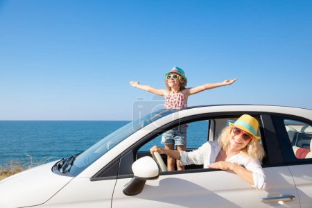 Foto de Feliz viaje familiar en coche en el mar. Madre e hijo divirtiéndose en cabriolet azul. Concepto vacaciones de verano - Imagen libre de derechos