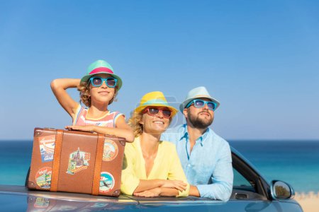 Foto de Feliz viaje familiar en coche en el mar. Madre, padre e hija divirtiéndose en cabriolet azul. Concepto vacaciones de verano - Imagen libre de derechos