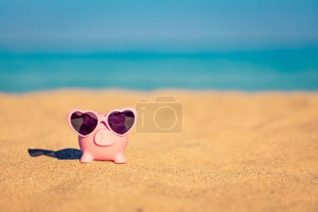 Photo for Piggybank on the beach against sea and sky background. Savings for summer travel and vacation concept - Royalty Free Image